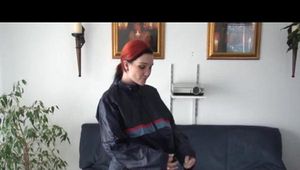 Jill DIamond lolling on a sofa wearing supersexy shiny rainwear (Video)
