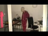 Blonde-haired archive girl being at home wearing shiny nylon rainwear (Video)
