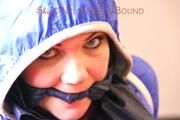 Jill tied and gagged on bed wearing a shiny black pants and a shiny blue rain jacket (Pics)