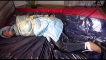 Lulu tied and gagged on a bed wearing a sexy blue shiny nylon rainpants and a iceblue PAMY downjacket (Video)