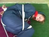 01:00 Min. video with an archive girl tied and gagged in shiny nylon rainwear