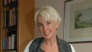 Pierced MILF Claudia posing in a knitted dress and pantyhose on the couch