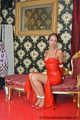 Miss Scarlett bound and gagged in a long red Latex dress