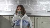 Miss J mit Kabelbindern gefesselt und streng geknebelt in einem Regenanzug verpack