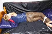 Samantha tied and gagged on bed wearing a brown shiny nylon downpanst and a blue downjacket (Pics)