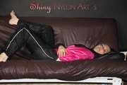 Watching Mara preparing bed and lolling and posing wearing a sexy shiny rain jacket and a rain pants (Pics)