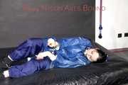 Lucy tied with cuffs overhead and gagged with a clothgag wearing sexy blue rain pants and a raincoat (Pics)