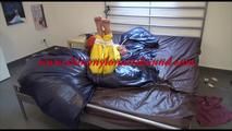 Pia tied and gagged on bed wearing a yellow rain pants and an orange downjacket (Video)