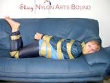 Leoni tied, gagged and hooded with tape wearing a sexy blue rainwear combination (Pics)