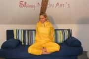 Sexy blonde archive girl posing and lolling on a sofa wearing sexy yellow rainwear over nothing (Pics)