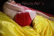 Sexy Sonja posing for you in a red shiny nylon shorts and a tshirts and then she takes it off and plays with the bedding (Pics)