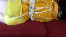 Lucy tied and gagged on a red sofa wearing a sexy yellow shiny nylon shorts and a yellow rain jacket (Video)