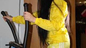 Sexy Lucy wearing a super hot yellow shiny nylon shorts and a yellow rain jacket during her workout on the crosstrainer (Pics)