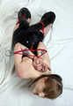 Amanda in leather corset and knee socks, frogtied with her hands in reverse prayer