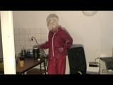 Blonde-haired archive girl being at home wearing shiny nylon rainwear (Video)