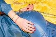 Alina wearing a sexy shiny rainwear suit in blue lolling on bed cuffed (Pics)