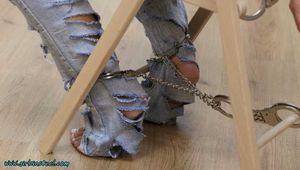 Hot jeans girl cuffed on a chair