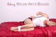 Pia tied and gagged on bed wearing a shiny darkblue nylon shorts with red stripes and white shirt (Pics)