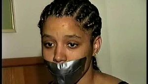 18 Yr OLD STUDENT SHANNA IS WRAP TAPE GAGGED, DUCT TAPE TIED, BAREFOOT, TOE-TIED, HANDCUFFED, MOUTH STUFFED, HANDGAGGED WHILE SITTING ON THE BED (D67-15)
