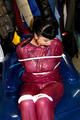 Jill tied and gagged in a semi-transparent purple PVC suit