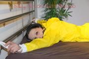 Lucy tied and gagged on bedposts face-down position wearing a sexy yellow shiny nylon shorts and a yellow rain jacket (Pics)