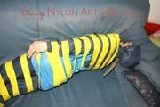 Katharina tied and gagged with tape on a sofa wearing shiny rainwear (Pics)