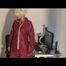 Blonde-haired archive girl being at home wearing shiny nylon rainwear (Video)