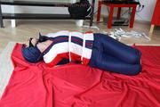 Julia tied and gagged in a shiny nylon skisuit