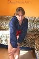 Leonie posing on a leopard sofa wearing a red shiny nylon shorts and an oldschool red/darkblue rain jacket (Pics)