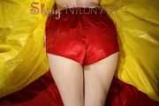 Sexy Sonja posing for you in a red shiny nylon shorts and a tshirts and then she takes it off and plays with the bedding (Pics)