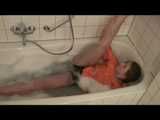 Watching sexy Katharina wearing a sexy black shiny nylon shorts and an orange downjacket enjoying her foambath (video)