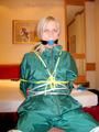Blonde archive girl tied and gagged in an green shiny nylon rainsuit on a chair (Pics)
