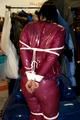 Jill tied and gagged in a semi-transparent purple PVC suit