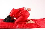 Jessy tied in a shiny nylon rainsuit