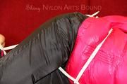 Mara tied and gagged on a red sofa wearing a sexy black rain pants and a shiny pink down jacket (Pics)