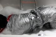 Simone in an shiny grey pvc sauna suit tied and gagged by Sophie in the bath tub (pics)