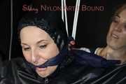 Sexy Mara tied, gagged and hooded overhead on hands and feet with ropes and a cloth gag wearing a sexy black/pink rainwear combination (Pics)