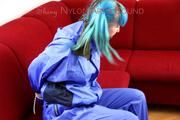 Mara tied and gagged on a red sofa wearing a sexy shiny lightblue rainwear (Pics)