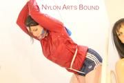 Jill tied and gagged on a stairway wearing a sexy blue shiny nylon shorts and a red rain jacket (Pics)