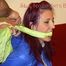 Mara tied and gagged on a sofa wearing a shiny black rain pants and a sexy lightblue down jacket (Video) 