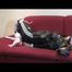 Samantha tied and gagged on a red sofa wearing a shiny black rainpants and a jacket (Video)