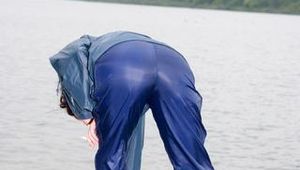 Sexy archive girl wearing a blue rain pant and rain jacket walking on a lake in freetime (Pics)
