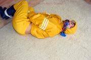 Katharina tied and gagged in a yellow rainsuit