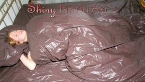 Katharina on bed wearing blue shiny nylon shorts and a white top (Pics)