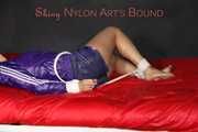 Sexy Pia being tied and gagged with ropes and a clothgag on a bed wearing a sexy darkblue shiny nylon shorts and a sexy blue/purple rain jacket (Pics)