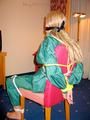 Blonde archive girl tied and gagged in an green shiny nylon rainsuit on a chair (Pics)
