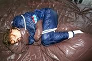 Stella tied and gagged in shiny nylon rainwear