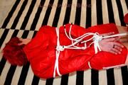 Marlin tied and gagged in red nylon shorts and red cagoule