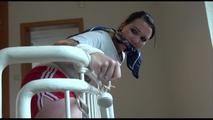 Jill tied and gagged on a stairrail wearing a sexy shiny red shorts with shadow stripes and a top (Video)