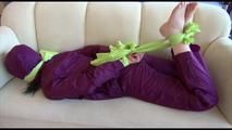 Mara tied and gagged on a sofa wearing a shiny purple rainwear combination (Video) 